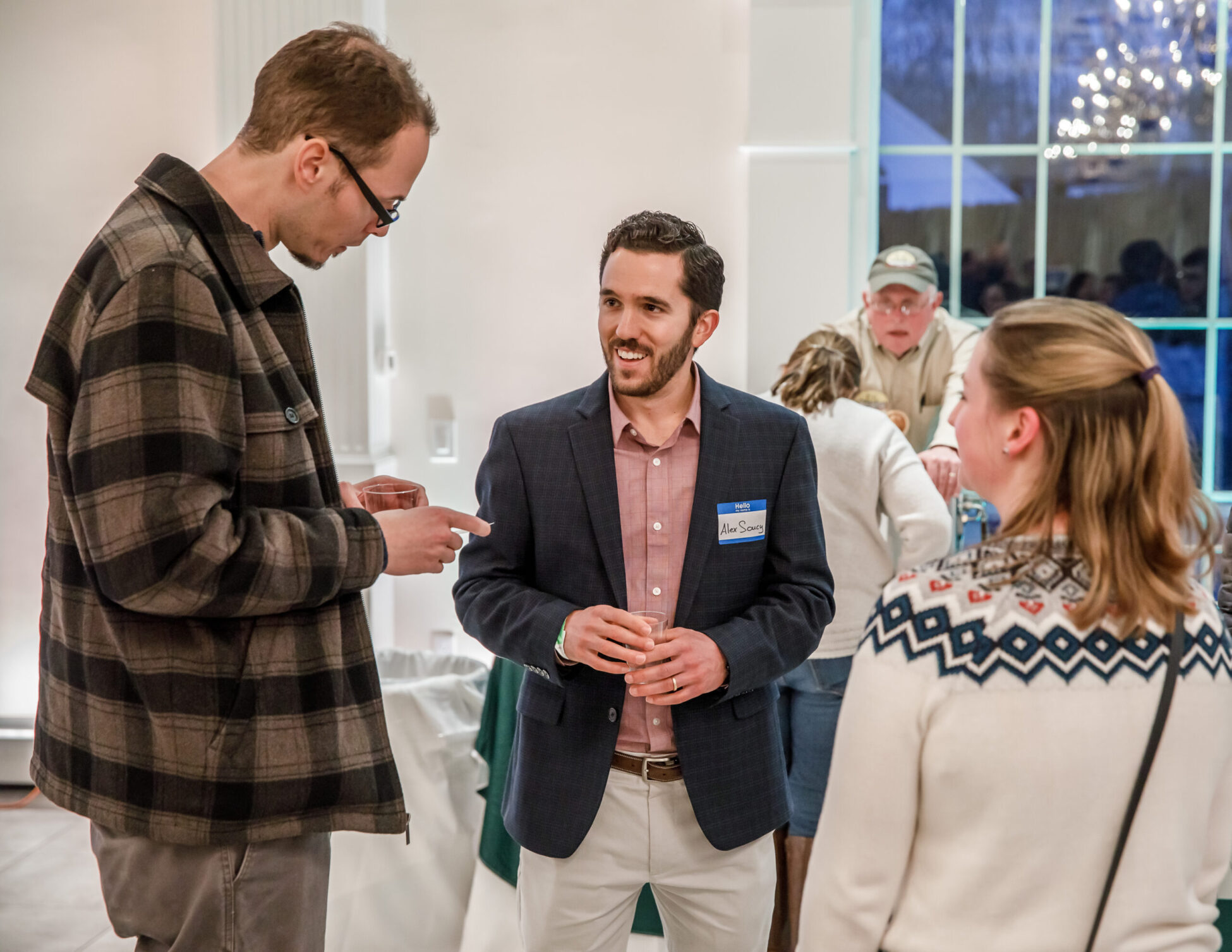 [Photo caption:] Alex Soucy, director of missions for Crossroads 4 Christ young adult group, chats with other young Catholics as they all sample beer at the Archbishop’s Annual Appeal Beer Tasting and Cocktail Reception Feb. 21 at the Aqua Turf Club in Plantsville. Photo by Aaron Joseph